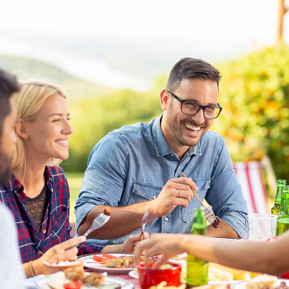 smiling guests eating dinner outside cabin